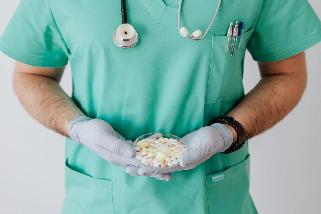 crop man doctor with stethoscope and medicine